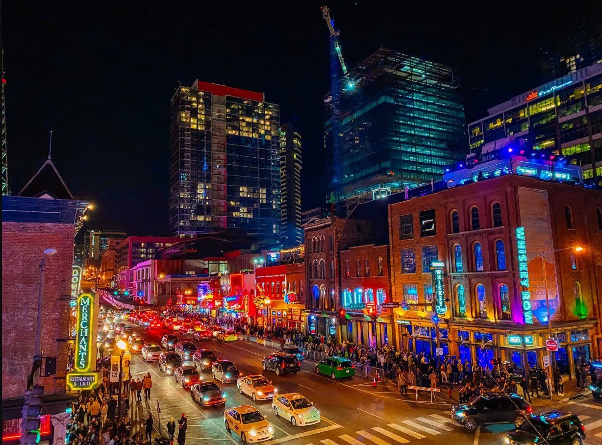Broadway Nashville at night with live music venues and tourism crowds near Alora Nashville Airbnb