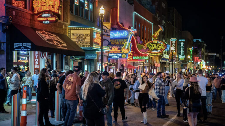 Crowds on Broadway in downtown Nashville at night showing tourism demand that drives Airbnb occupancy and revenue