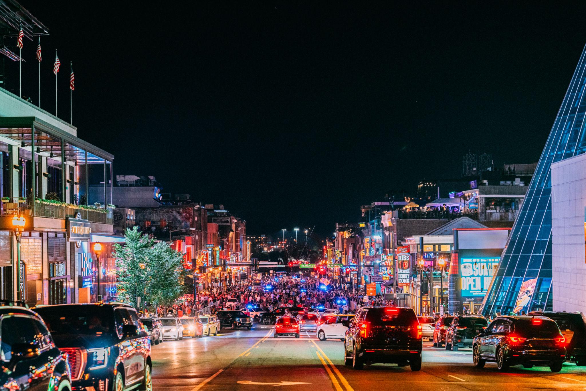 Busy downtown Nashville street showing tourism activity and economic growth at night