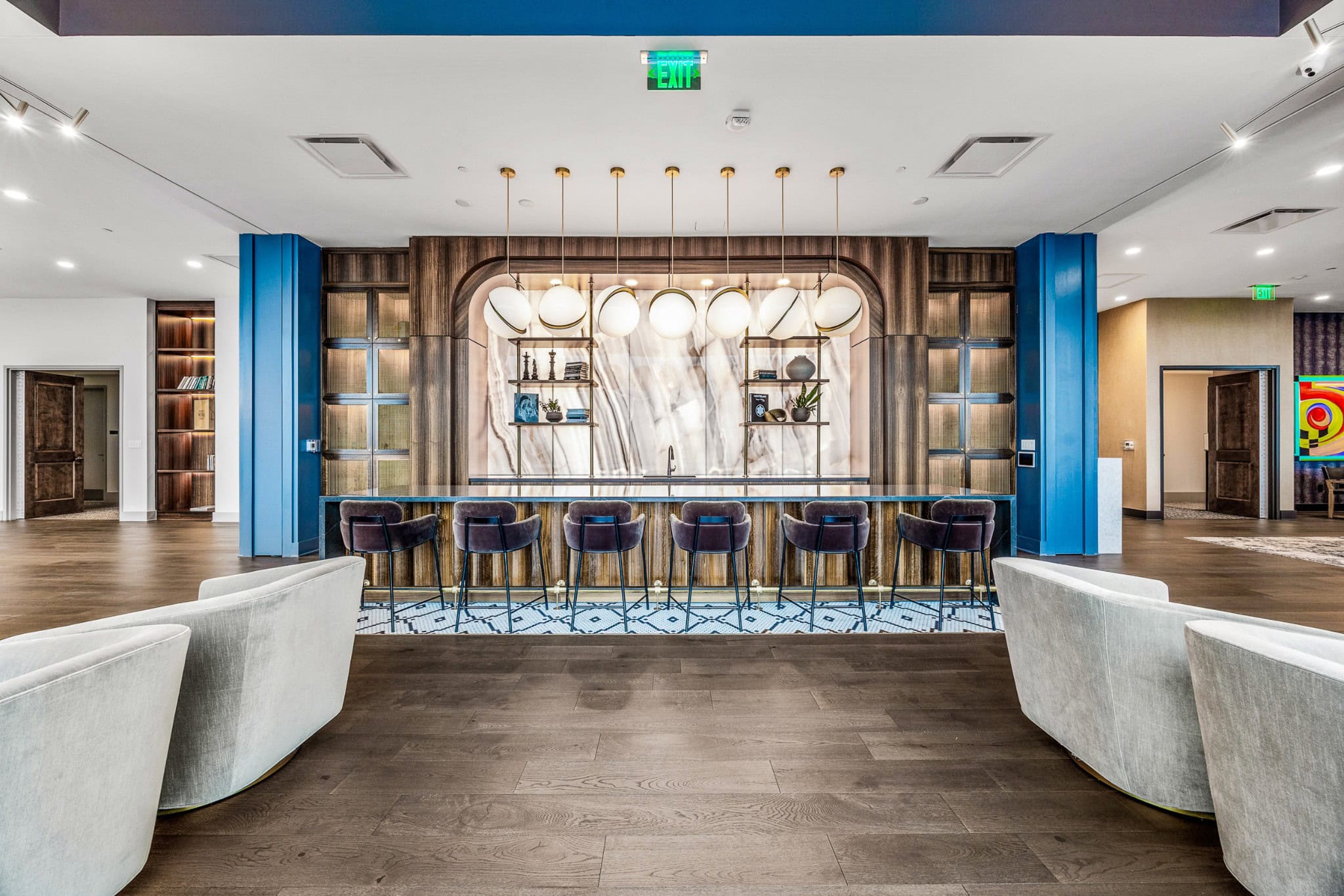 Residences at Broadwest amenity floor with golf simulator, lounge, and full-service bar