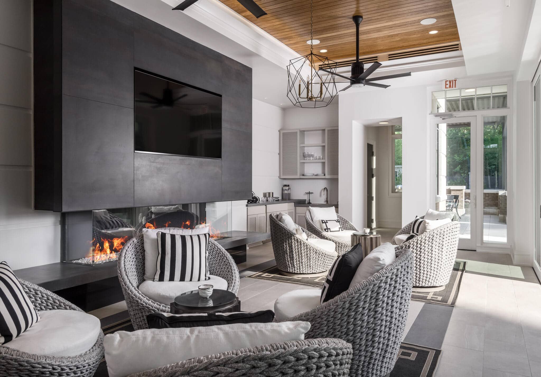 Pool pavilion lounge at The Manning Belle Meade with linear gas fireplace, woven wicker chairs, geometric chandelier