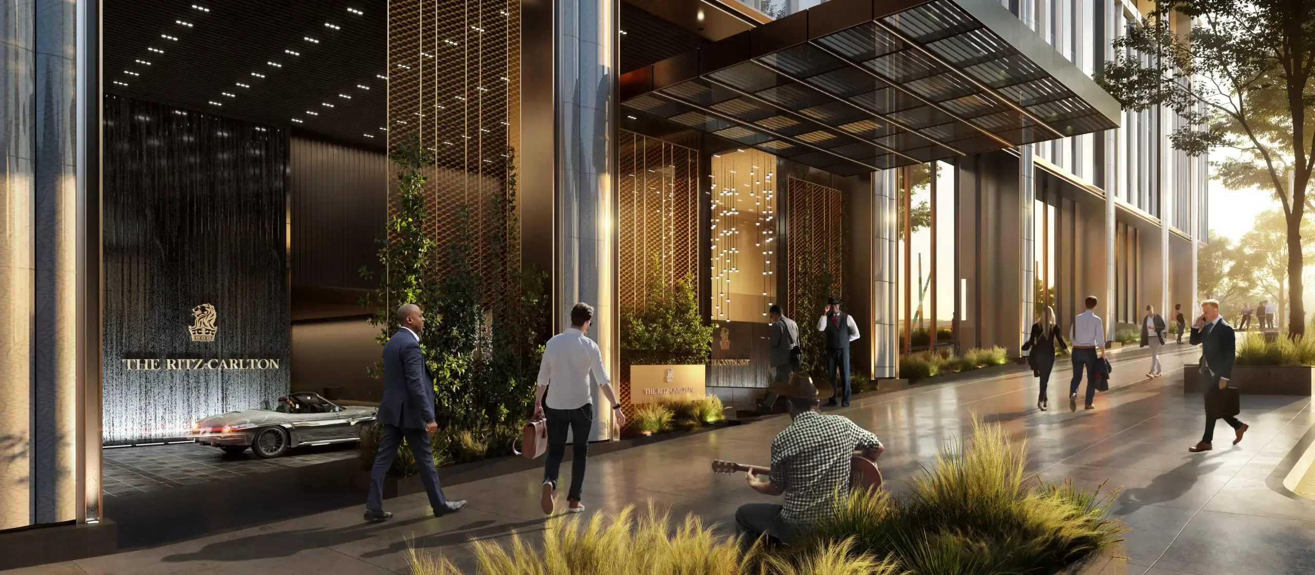 Rendering of the porte-cochere entrance to the planned Ritz-Carlton hotel and condominium tower in the Gulch, Nashville, with the Ritz-Carlton wordmark on a stone water wall and a cantilevered glass canopy over the drive