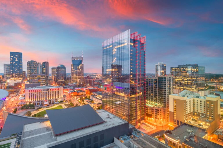 Downtown Nashville skyline at dusk, with the AT&T Building and lit glass condo towers rising above the city core